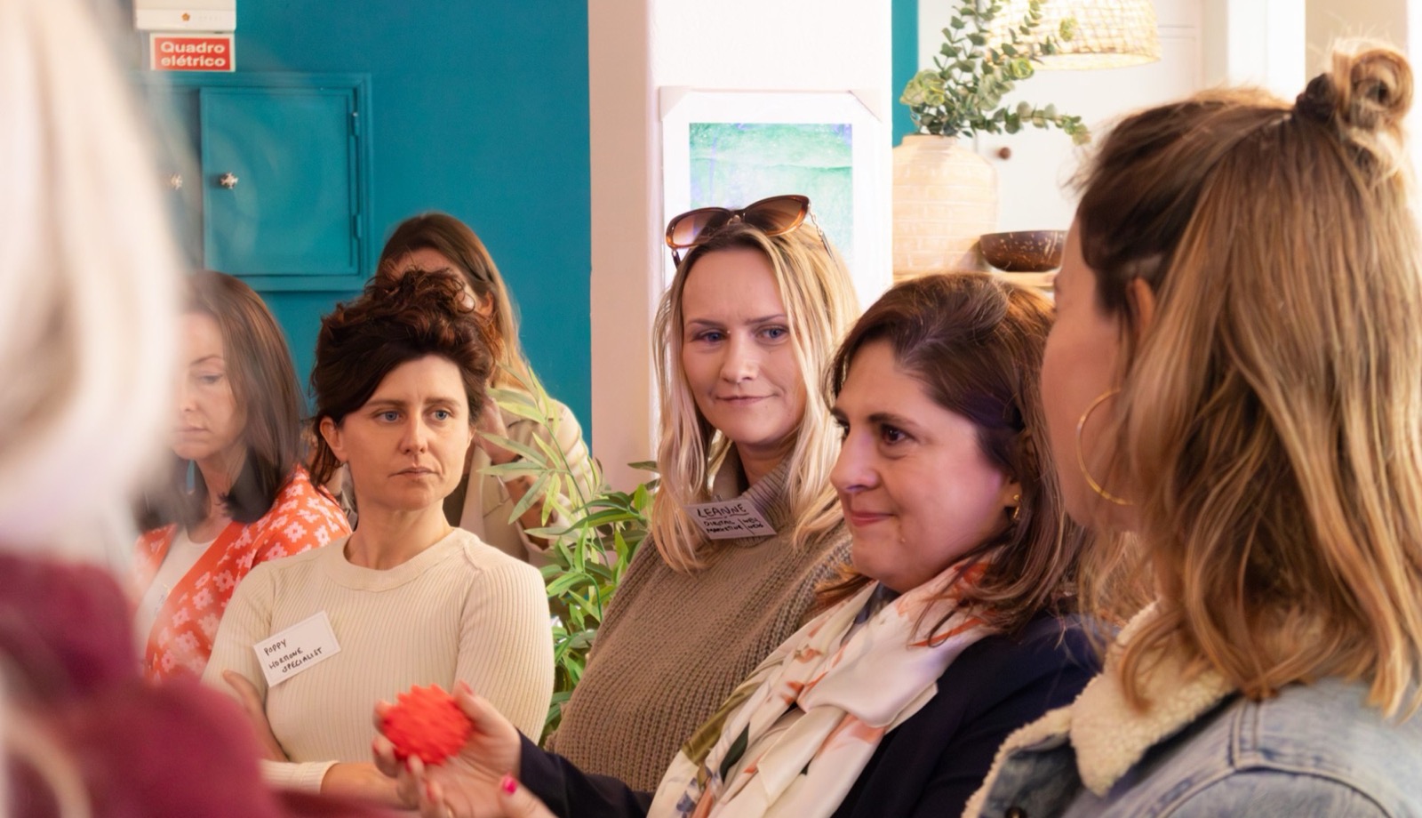 A circle of women talking and laughing at an event